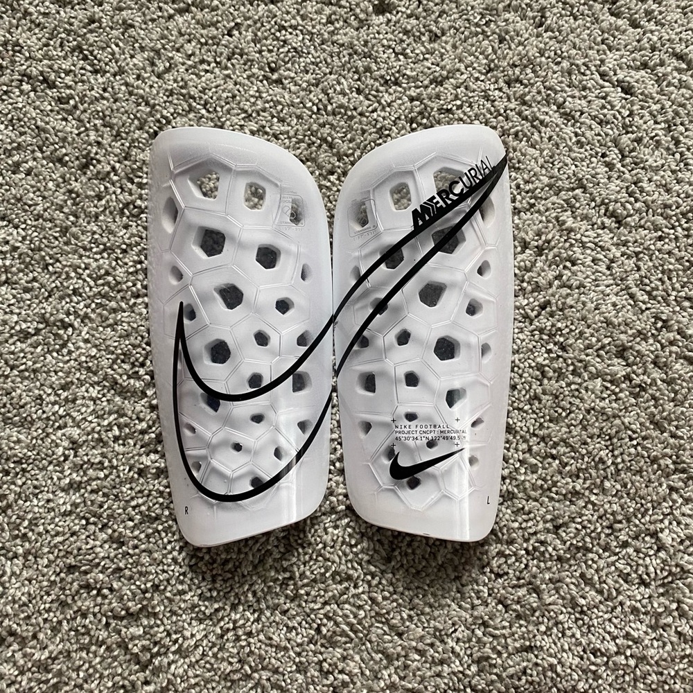 White Nike shinguards size large.